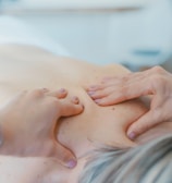 person massaging the back of a woman